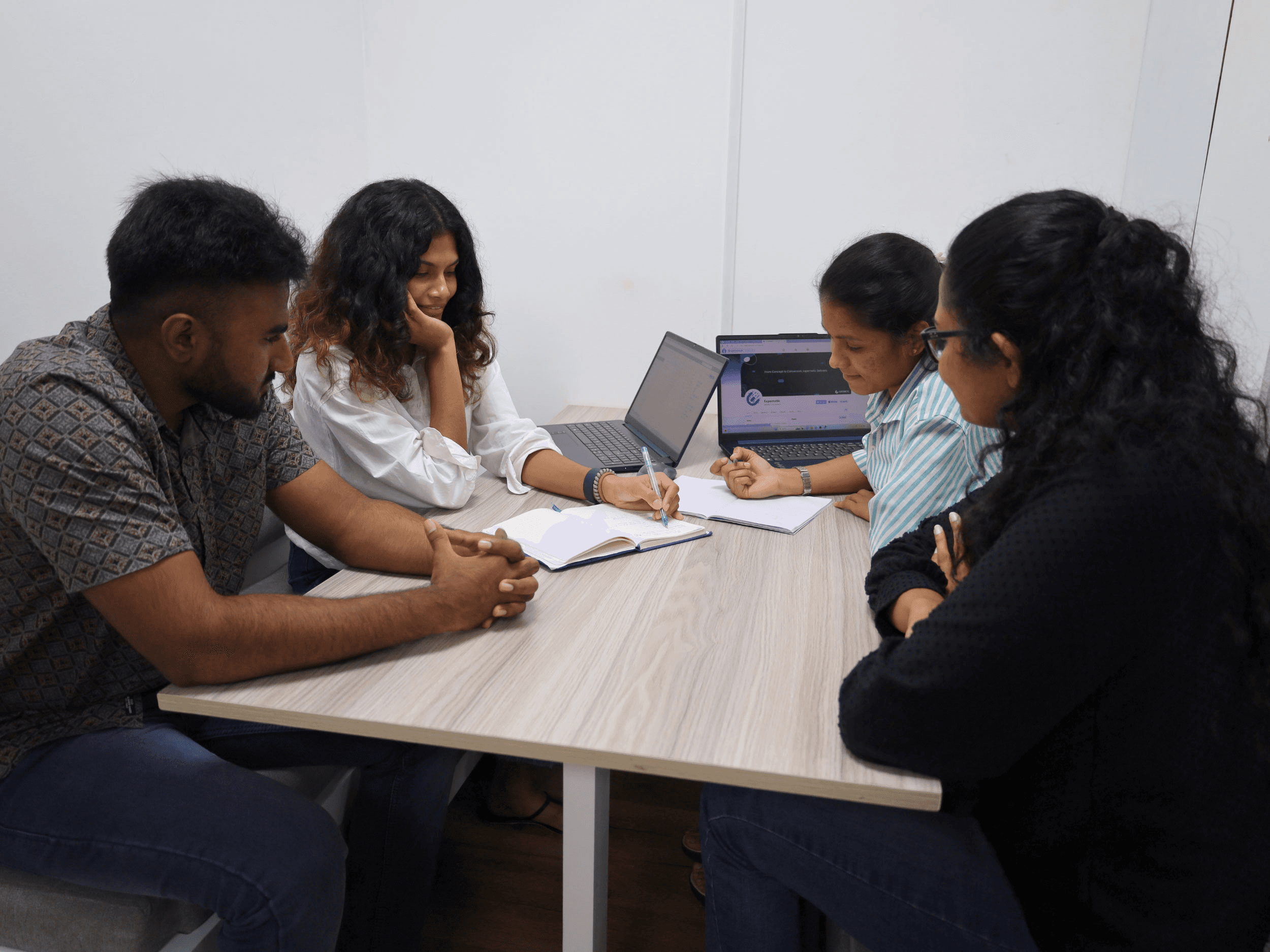 Employees brainstorming and taking notes on notebooks