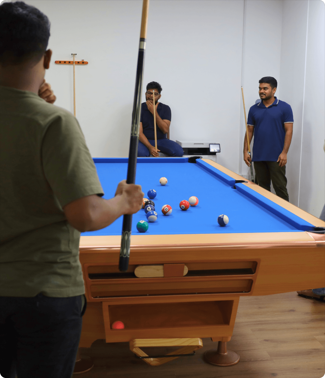 Employees engaged in a competitive game of pool