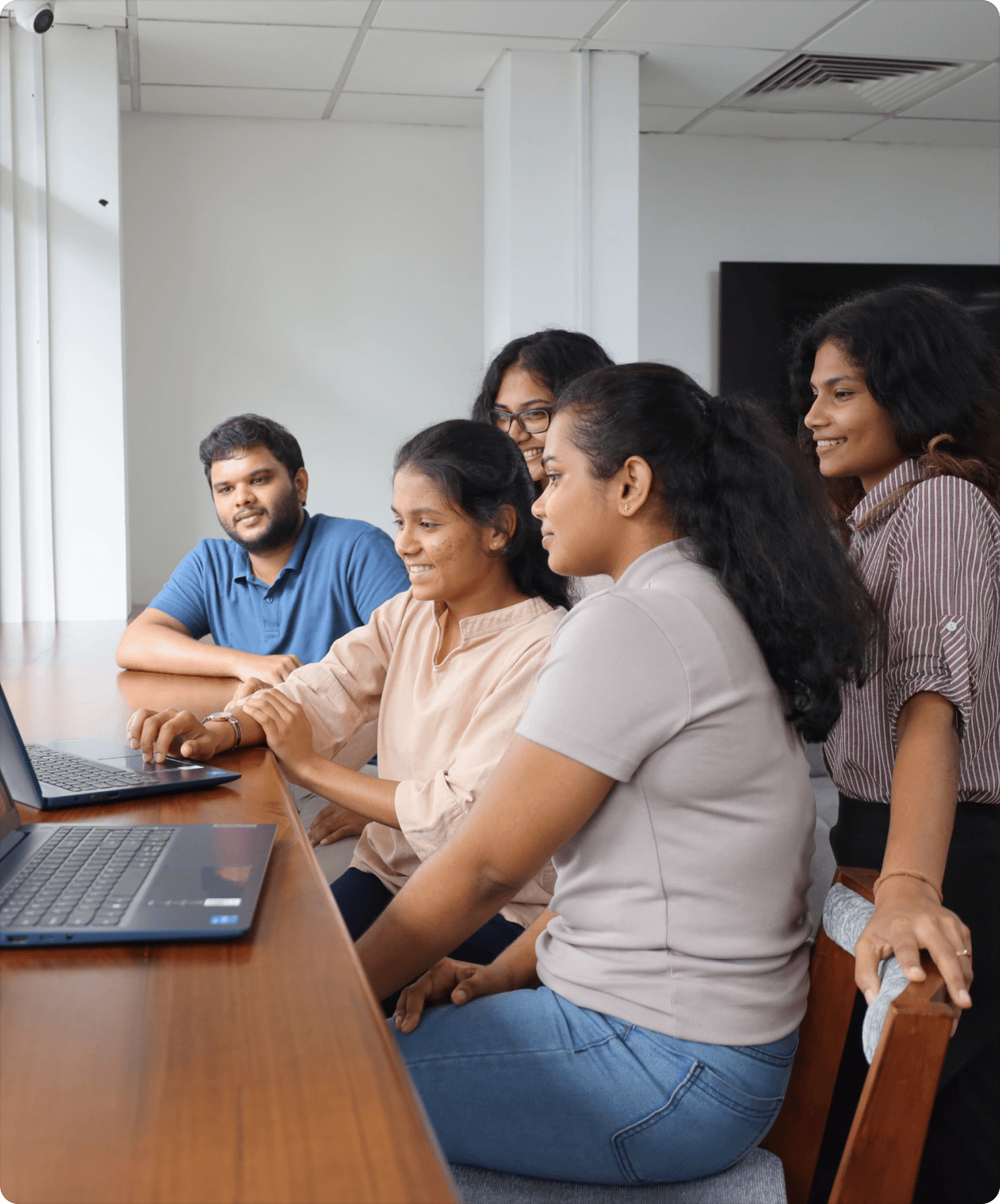 Office workers gathered around a laptop